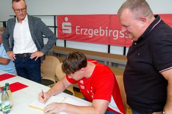 Europameister im Rampenlicht: Heimatgemeinde im Erzgebirge ehrt ihren Goldjungen - Steven Richter trägt sich im Beisein von Bürgermeister Knut Schreiter (r.) und Jens Römling (l.) von der Erzgebirgssparkasse in das Goldene Buch von Gelenau ein.