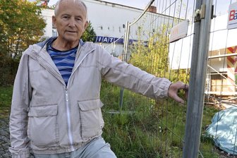 Ex-Autohaus-Chef aus Zwickau erinnert sich: Eine Tankstelle, an der jeder gute Laune hatte - Ex-Autohaus-Chef Harald Meichsner vor dem Bauzaun um die Tankstelle. Hinten war das Autohaus.