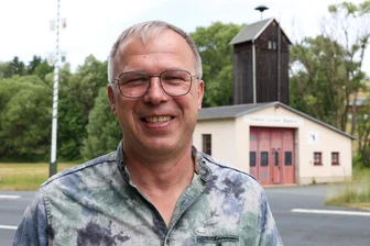 Ex-Porzellanfabrik beliebter Lost Place im Herzen des Vogtlandes: Was den Ortsvorsteher von Mühlhausen im Jubiläumsjahr bewegt - Ortsvorsteher Bernd Bräunlich (UB) vor dem alten Gerätehaus der freiwilligen Feuerwehr, das in Mühlhausen ortsbildprägend ist.