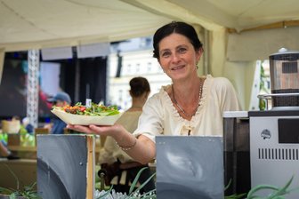 Fabulix: Was kostet das Essen beim Märchenfilmfestival? - Ein Besuch in der Fabulix-Stadt macht hungrig. „Freie Presse" hat genau auf die Teller geschaut. Hier ist es Ina Salzmann, die eines von elf Gerichten reicht, dass das 13-köpfige Elldus-Team an den Festivaltagen in den drei Zelten auf dem Festivalgelände serviert.