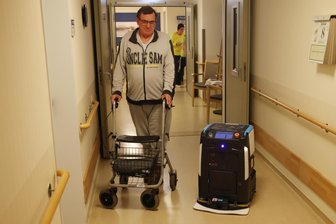 Fachkräftemangel: Zwickauer Pflegeheim setzt jetzt auf Reinigungs-Roboter - Bewohner Olaf Unger und „Cobi 18“ begegnen sich im Gang in der dritten Etage. Der Roboter hatte im Pflegeheim am Schlobigpark am Mittwoch seinen ersten Tag.