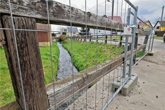 Das morsche Geländer "Am Bach" in Falken wird mit einem Absperrgitter gesichert.