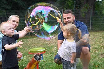 Falkenaus Knirpse haben Spaß mit Riesenseifenblasen und Gartenpolonaise - Seifenblasen-Spiele: Vati Tommy Hunger mit Mirella rechts und Liam mit Nicole Förster.