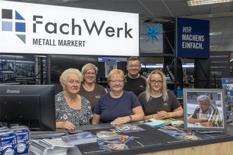 Familienbetrieb im Erzgebirge steht nach mehr als 30 Jahren vor dem Aus - Es ist wohl eines der letzten gemeinsamen Fotos im Crottendorfer Markt der Firma Metall Markert. Diese stellt den Geschäftsbetrieb ein. Bald beginnt der Räumungsverkauf. Im Bild: Helga Markert, Manuela Wollesen, Jana Linke, Udo Markert und Luisa Richter (v. l.). Auf dem Bild rechts zu sehen: der verstorbene Gründer Frieder Markert.