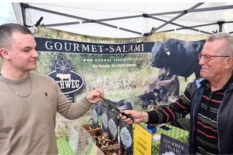 Fangemeinde für „Landbumml“ Niederwiesa wächst: Verkosten, Schnuppern und Shoppen - Pietje Jantos kostet von der Edelsalami vom Wagyu-Rind, die Wolfgang Dolewa aus Grimma beim „Landbumml“ am Naturbad in Niederwiesa kredenzte.