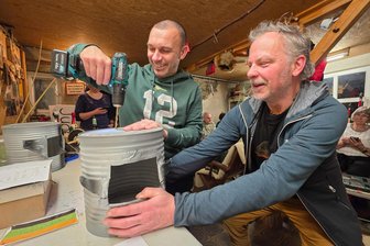 Faschingsumzug: Diese Vogtländer rücken als Raubritter an - Sandro Röder (links) und Holger Uebel vom Dorfclub Jugelsburg basteln Ritterhelme aus Blechbüchsen, die beim Faschingsumzug in Adorf zum Einsatz kommen.
