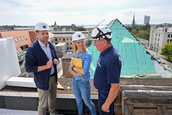 Fast 200 neue Wohnungen für Chemnitz: Rundgang auf der Baustelle „Stille Post“ am Hauptbahnhof - Bauleiter David Schenk, Prokuristin Mandy Klabes und Polier Uwe Münzner auf dem Dach des Neubaus des Lewo-Projektes „Stille Post“.