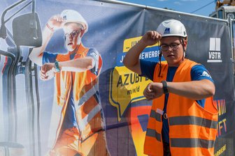 Fast wie im Actionfilm: Vogtländische Bauarbeiter werden auf Plakaten zu Stars – „Das sind die Helden der Straße“ - Toni Prause (20) wirbt als Zeitreisender Marty McFly für eine Zukunft als Azubi beim VSTR. Er selbst hat dort drei Jahre gelernt. Jetzt arbeitet er als Baugeräteführer.