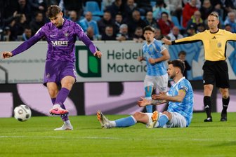 FC Erzgebirge Aue kämpft Chemnitzer FC im Halbfinale des Fußball-Sachsenpokals nieder - CFC-Kapitän Dejan Bozic sitzt am Boden, während Tristan Zobel von Aue den Ball hat.