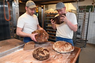Feinschmecker kommen im Wasserschloß Klaffenbach zum Verkosten - Kutscher-Rad heißt die Brotvariation, die Firmenchef Tobias Nönnig, links, mit seinem Mitarbeiter und Meister, Brotsommelier Toni Hager, auf seine Qualität hin checkt.
