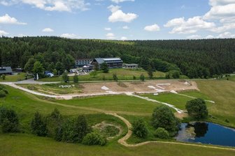 Ferienhausprojekt am Fichtelberg: Naturschützer erringen vor Gericht nächsten Erfolg - Unterhalb des Hotels von Jens Weißflog erstreckt sich an der Emil-Riedel-Straße in Oberwiesenthal das Areal, auf dem die drei Ferienhäuser entstehen sollten. Seit Ende Mai gilt ein Baustopp.