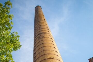 Fernwärme: Preissteigerung auch in Flöha - Der markante 70 Meter hohe Ziegel-Schornstein ist das Erkennungszeichen des Heizkraftwerkes auf dem Gelände der Alten Baumwolle. Hier wird die Fernwärme für große Teile der Stadt produziert. 