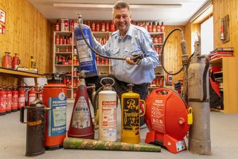 Feuerlöscher-Museum im Erzgebirge eröffnet: Andreas Kroschk ist Feuer und Flamme - Nicht alle Exponate sind rot oder haben die typische Form. Andreas Kroschk mit einigen Feuerlöschern seiner riesigen Museums-Sammlung - das rote, runde Teil etwa war für die U-Bahn in Honkong im Einsatz.
