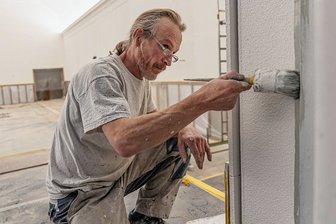 Feuertaufe für Akustik im Rodewischer Ratskellersaal naht - Vorarbeiter Matthias Anger von der Malerwerkstatt Mehlhorn in Aue verpasst den Stuckelementen der Bühnenwand frische Farbe.
