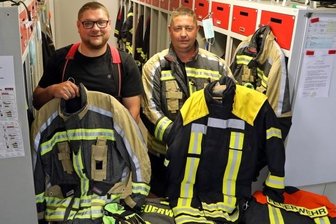 Feuerwehr erhält moderne Schutzkleidung - Gemeindewehrleiter Rico Leuschner (links) zeigt eine der alten Jacken, Ortswehrleiter Sven Weinhold die neue Ausrüstung.