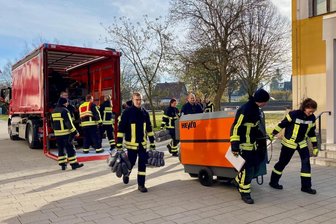Einrichten als Notquartier: Die Feuerwehren Freiberg und der Stadtteile Zug und Kleinwaltersdorf während ihrer Übeung am Samstag. Die Freiberger Ohain-Oberschule wurde für einen Brandfall umgerüstet.