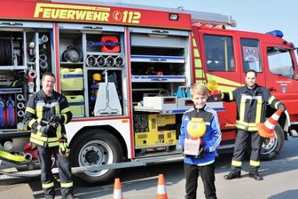 Feuerwehr revanchiert sich bei jungem Falkenauer - Kamerad Sven Stenker (l.) und der stellvertretende Wehrleiter Bjön Bork (r.) von der Freiwilligen Feuerwehr Falkenau zeigten dem elfjährigen Tyler Tanneberger (M.) das Feuerwehrdepot und die Fahrzeuge.