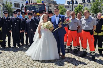 Feuerwehr und Rettungsdienst feiern ein Brautpaar in Rochlitz - Kevin Heinrich und Christin Günther haben sich am Samstag das Jawort gegeben. Danach erhielten sie Glückwünsche von Feuerwehrleuten und Rettungsdienst-Kollegen des Bräutigams.