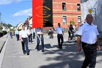 Feuerwehr Unterheinsdorf: Warum der Festumzug zum Jubiläum eher zu hören als zu sehen war - Wehrleiter Uwe Eichhorn und das Fahnenkommando laufen gleich hinter der Schalmeienkapelle.