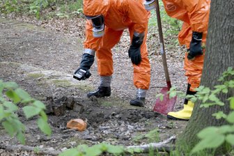 Feuerwehr untersucht verdächtige Ampullen in Chemnitzer Wald - Einsatzkräfte untersuchen in Vollschutz Ampullen im Wald.