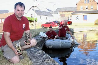 Feuerwehren suchen den Vogtländischen Oberspritzer - Mit dem Schlauchboot durch den Feuerlöschteich, so wie hier Maik Burkhardt und Olaf Roth, das gilt für die Teams beim Oberspritzer-Wettbewerb. Im Vordergrund zeigt Ortswehrleiter Sven Burkhardt die Siegerpokale.