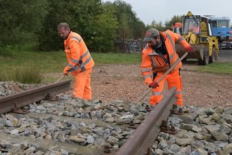 Feuerwehrleute können künftig an einer Tatra-Bahn üben - Sven Schäfer (links) und Michael Pflugbeil vom Bauhof der Gemeinde Jahnsdorf mussten zuvor an der "Rampe" Hand anlegen, an die dann der Spezialtransporter mit dem Triebwagen zentimetergenau heranbugsiert wurde.