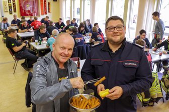 Feuerwehrübung endet mit Testessen: Warum der Hotdogsachse die Feuerwehr Hohenstein-Ernstthal eingeladen hat - Thomas Hamm (l.), in Hohenstein-Ernstthal bekannt als Hotdogsachse, versorgte die Feuerwehr nach der Übung mit einem Mittagsimbiss. Gemeindewehrleiter Rico Leuschner (r.) freut sich über das kulinarische Dankeschön.