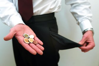 Finanzschock in Burgstädt: Rückzahlung von 1 Million Euro Gewerbesteuer - Leere Hosentaschen und eine Hand mit Euromünzen. Ein Symbolbild für klamme Kassen.