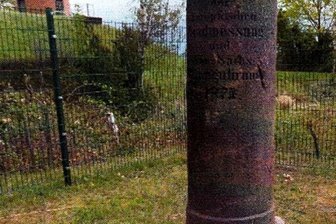 Fixpunkt aus Porphyr neben dem Dorf - Die Triangulationssäule im Schönberger Ortsteil Pfaffroda. Im Bild links ein RZV-Gebäude. 