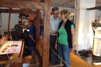 Flämisches Manchester zu Gast im sächsischen - Vorschlag Bildtext: Oliver Brehm, Direktor des Industriemuseums Chemnitz, erklärt seiner Amtskollegin Ann Van Nieuwenhuyse aus dem belgischen Gent die Funktionsweise eines Webstuhls im Untergeschoss seines Hauses an der Zwickauer Straße.