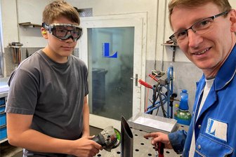 Flexen statt Englisch: Modellprojekt gegen Lehrermangel im Vogtland erinnert an Fach aus DDR-Zeiten - Lenny mit Ausbilder Jens Görisch (rechts) in der Werkstatt des Aluminiumtubenherstellers Linhardt in Pausa.
