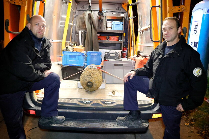 Sven Redmer (links) und Thomas Zowalla vom Kampfmittelbeseitigungsdienst mit dem entschärften Bombenkörper.