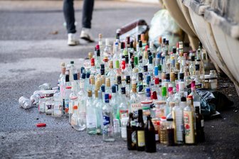 Flöha: Flasche trifft Frontscheibe - Glasflaschen stehen neben einem überfüllten Glascontainer.