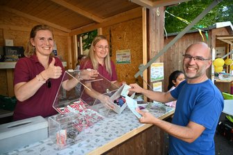 Flöhaer feiern ihr 22. Straßenfest mit einem lachenden und einem weinenden Auge - Enrico Weiße versucht sein Glück an der Tombola beim Straßenfest in Flöha: Anika Mehlis (l.) und Kristin Flaxa halten Gewinne bereit.
