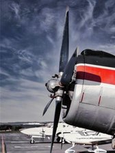Flugplatz Jahnsdorf: Rundflüge und Probesitzen für Hobby-Piloten - Gewitterhimmel über einem silberroten Doppeldecker auf dem Flugfeld