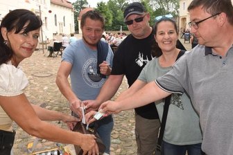 Flut: Mittelsachsen hilft mit guten Ideen - Astrid Grübner (links) behielt bei der Aktion von Ritter Harras alias Rolf Pönicke in Lichtenwalde die Spendenbox im Blick. Zahlreiche Zuschauer gaben Geld, auch Mike Endtmann (rechts) aus Lichtenwalde. 