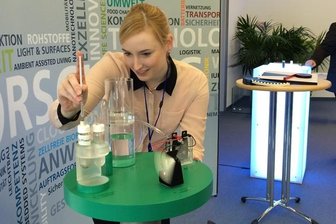 Julia Scholz betreut ein Funktionsmodell. Eine graue Paste liefert den Energieträger.