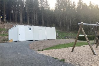 Fortschritt bei Toiletten-Neubau in Muldenhammer: Jetzt fehlt noch eine Genehmigung - Der Toilettencontainer am Festplatz wird nun mit Holz verkleidet und bedacht.