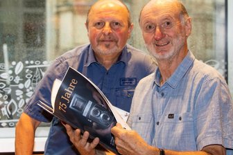 Fotoclub feiert 75-Jähriges - Clubchef Jürgen Zorn (rechts) und sein Vize Bernd Hegner blättern in der druckfrischen Broschüre, die sich der Fotoclub Vogtland zu seinem Jubiläum gegönnt hat.