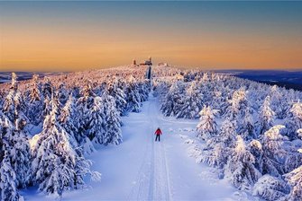 Fotowettbewerb für das Erzgebirge: Das sind die Siegerbilder der Winterrunde 2021 - Einen Sonnenuntergang auf dem verschneiten Fichtelberg hat Jenny Sturm aus Kabelsketal in Sachsen-Anhalt eine tolle Kulisse beschert, die sie fotografisch hervorragend in Szene setzte. Tiefenwirkung, Bildausschnitt, Zusammenspiel der Farben und als i-Tüpfelchen der Skiläufer in roter Jacke: Ein rundum stimmiges Foto. 