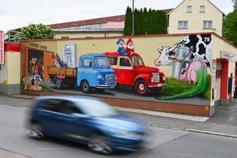 Framo, Barkas und Striegistaler Zwerge: Für dieses Wandbild wird in Hainichen sogar eine Straße gesperrt - Das Graffiti an der Autowaschanlage an der Mittweidaer Straße 75 zeigt Produkte aus Hainichen. Hinter Barkas und Framo finden sich im Warenlager auch Teddyplüsch, gedrechselte Schneemänner, Kerma-Verbandstoffe, Teppiche und Tapeten.