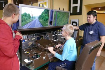 Französische Technik ermöglicht Spritztouren mit 300 km/h - Die Brüder Maik und Ronny Zuschlag (von links) sind fasziniert von dem Cockpit samt Zugsimulator, an dem auch Martin Rösch (rechts) vom Zschopauer Modellbahnverein mitgebastelt hat.