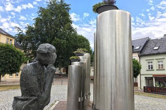 Frauenstein: Blumenschalen auf Silbermannbrunnen stoßen auf geteiltes Echo - Auf den Orgelpfeifen des Silbermannbrunnens auf dem Marktplatz in Frauenstein – hier ein Foto von Mitte Juli – stehen Pflanzschalen mit Blumen.