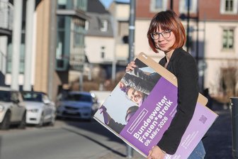 Frauenstreik in Zwickau: „Es geht darum, Ungleichheiten sichtbar zu machen“ - Jenny Bück hängt Plakate für den Frauenstreik am 9. März auf.