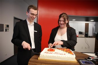 Fraureuth: Azubi-Team managt ab sofort Sparkassen-Filiale im Dorf - Zum Auftakt gab es sogar eine Torte: Nico Goldhahn und Jennifer Riller gehören zum Azubi-Team, das ab sofort die Sparkassen-Filiale in Fraureuth betreut.