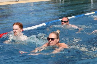 Freibad-Saison in Neukirchen: Warum die Versicherung nach Hochwasser nicht alles zahlen will - Die Triathleten im Wasser des Freibades Neukirchen.