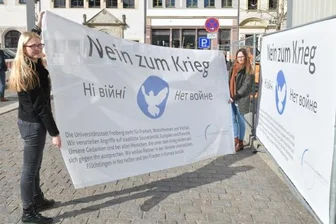 Freiberg erlebt hundertfachen Protest gegen Krieg in Ukraine - Sandra Eberbach und Anja Ksienzyk von der Stadtverwaltung Freiberg haben am Mittwoch zwei Friedensbanner an einem Bauzaun nahe des Bürgerhauses am Obermarkt angebracht. 