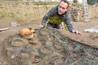Freiberg: Goldene Nelken im Kindergrab - Dutzende Kränze aus Holzspänen, umwickelt mit filigranem Kupferdraht und Blütenornamenten, bedecken diesen Leichnam, den Grabungsleiter Matthias Schubert am Dom St. Marien in Augenschein nimmt.