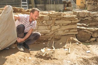 Freiberg: Grabungen am Dom bringen unbekannte Mauern zum Vorschein - Vor einer frei gelegten Mauer zeigt Grabungsleiter Matthias Schubert auf dem Grünen Friedhof des Freiberger Doms Grabstellen.