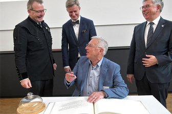 Freiberg: Stadt ehrt Wissenschaftler der Bergakademie mit Eintrag ins Goldene Buch - Professor Helmuth Albrecht trägt sich ins Goldenen Buch ein. Mit dabei waren OB Sven Krüger, Staatssekretär Andreas Handschuh und Rektor Klaus-Dieter Barbknecht (v. l.).